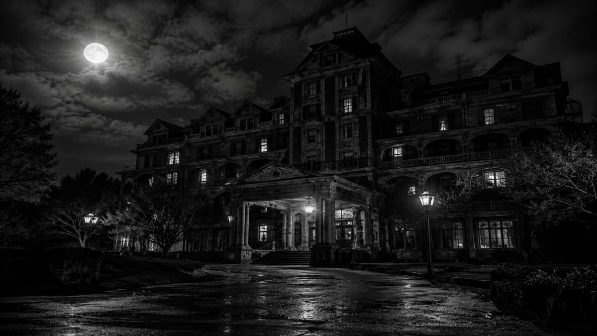 Un hotel antiguo bajo la luz de la luna, envuelto en misterio